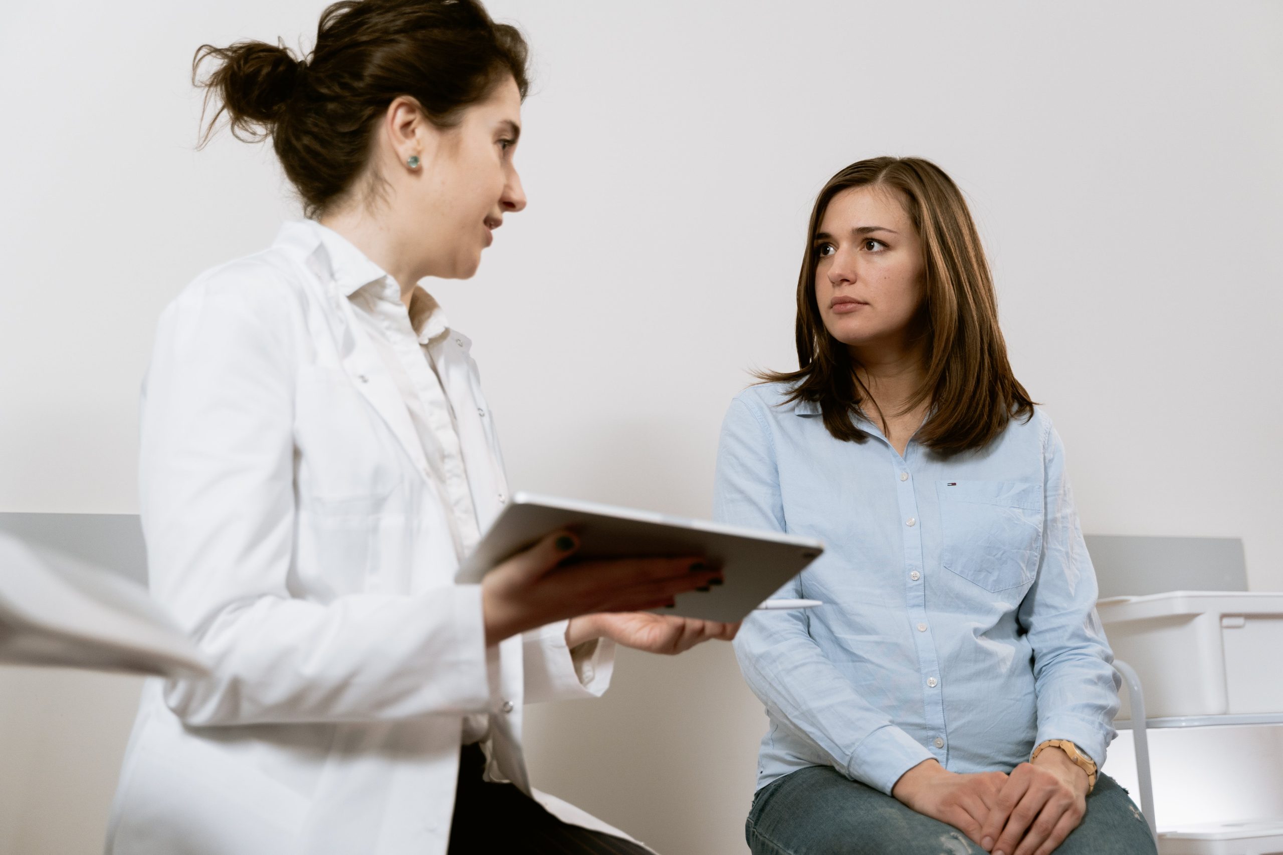 A woman seeking guidance from a healthcare professional regarding pregnancy symptoms and concerns.